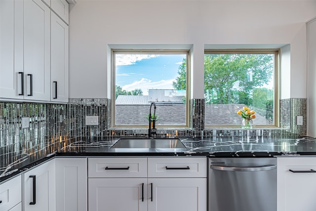 kitchen featuring sink, dark stone countertops, backsplash, stainless steel dishwasher, and white cabinets