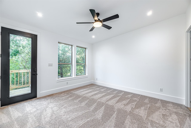 spare room with ceiling fan, a healthy amount of sunlight, and light carpet