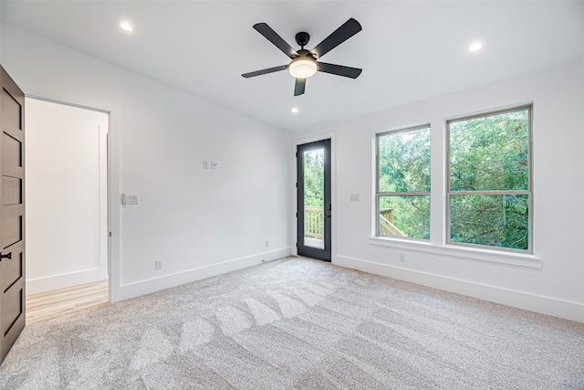 carpeted spare room with a wealth of natural light and ceiling fan