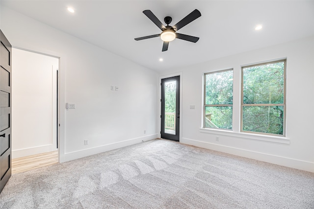 carpeted spare room featuring ceiling fan