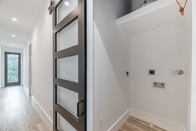 clothes washing area with light hardwood / wood-style flooring, hookup for a washing machine, and hookup for an electric dryer