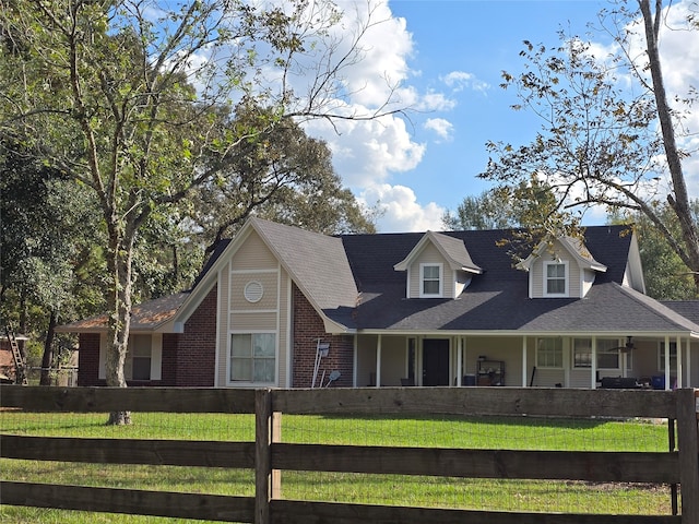 cape cod home featuring a front lawn and a porch