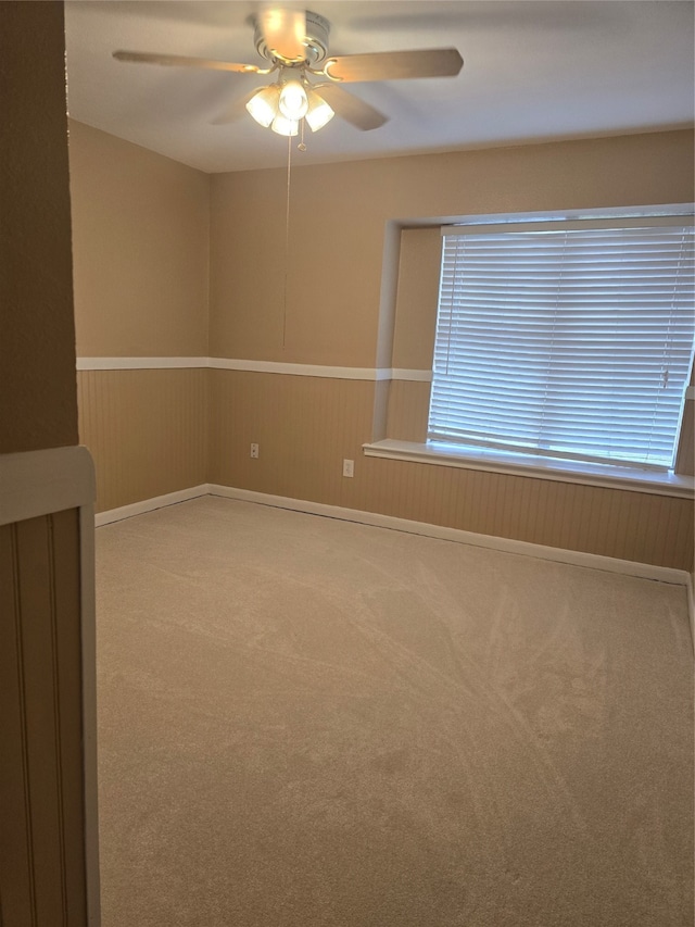 carpeted spare room featuring ceiling fan