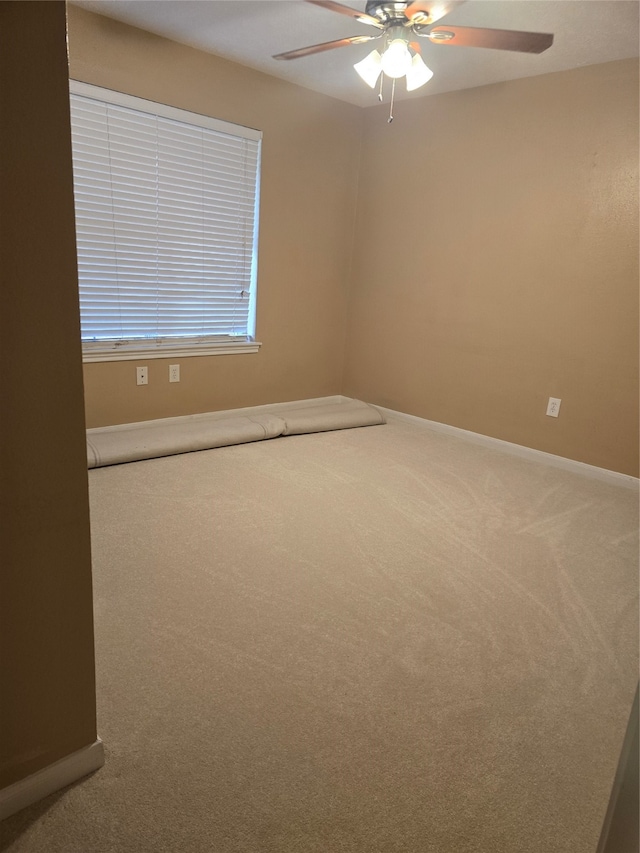 carpeted spare room featuring ceiling fan