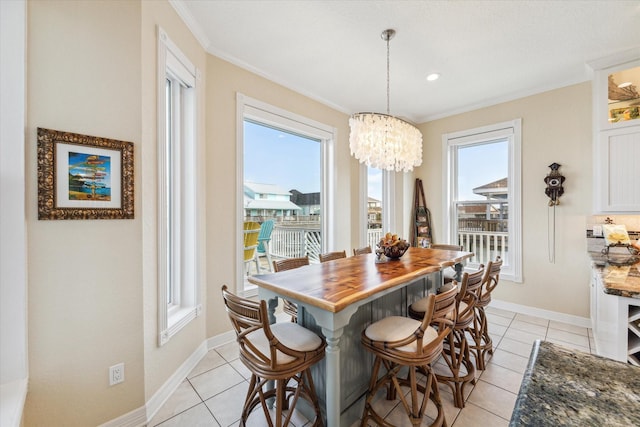 tiled dining space featuring crown molding and a chandelier