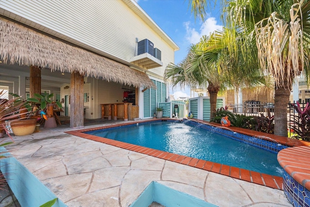 view of swimming pool featuring pool water feature, an outdoor bar, and a patio