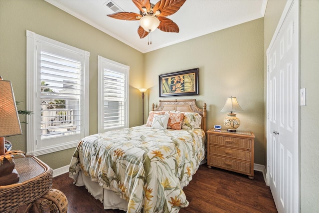 bedroom with a closet, ornamental molding, dark hardwood / wood-style floors, and ceiling fan