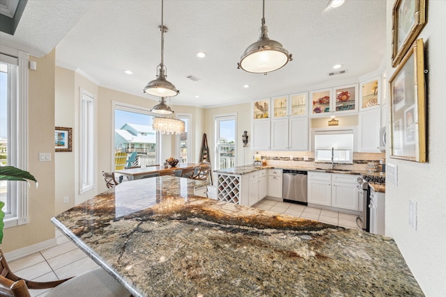 kitchen with stainless steel appliances, white cabinetry, backsplash, decorative light fixtures, and sink