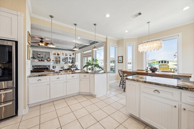 kitchen with dark stone counters, decorative light fixtures, and white cabinets