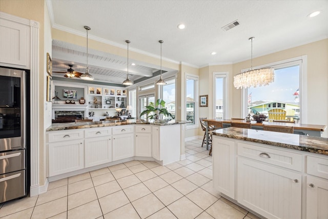 kitchen featuring hanging light fixtures, white cabinetry, and dark stone countertops