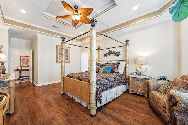 bedroom with a tray ceiling, dark wood-type flooring, and ornamental molding