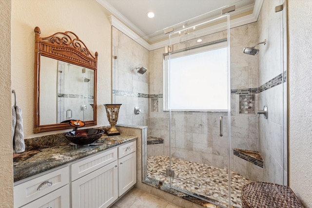 bathroom with a shower with door, crown molding, and vanity