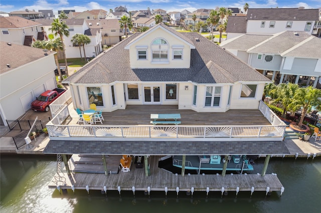 rear view of property with french doors and a deck with water view