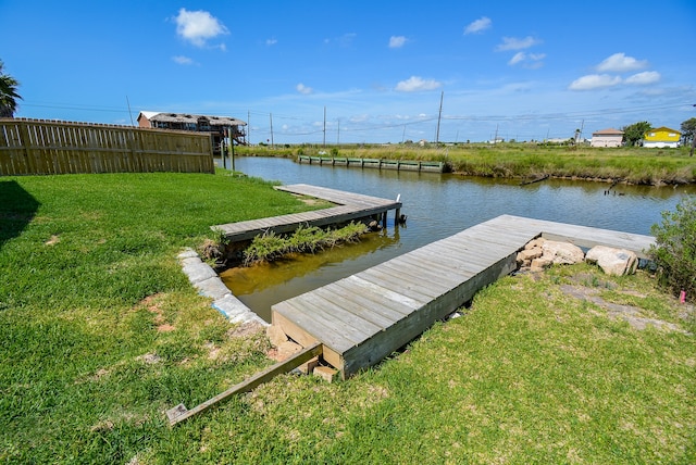 dock area featuring a water view and a lawn