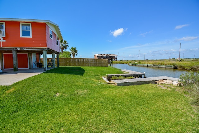 view of yard with a water view and a boat dock