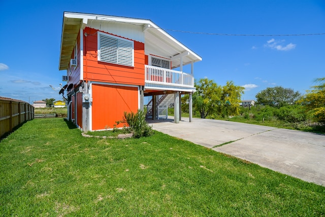 rear view of house with a lawn and a carport