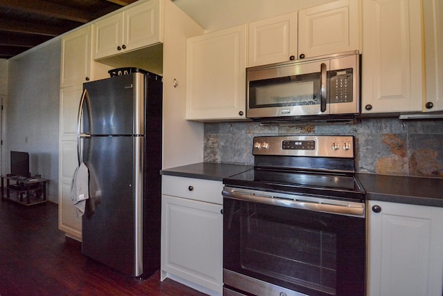 7120 E Hunter Dr, Hitchcock, TX 77563 - kitchen with appliances with stainless steel finishes, dark countertops, white cabinets, and dark wood finished floors