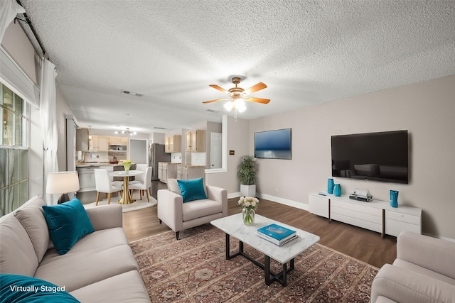 living room with a textured ceiling, hardwood / wood-style floors, and ceiling fan