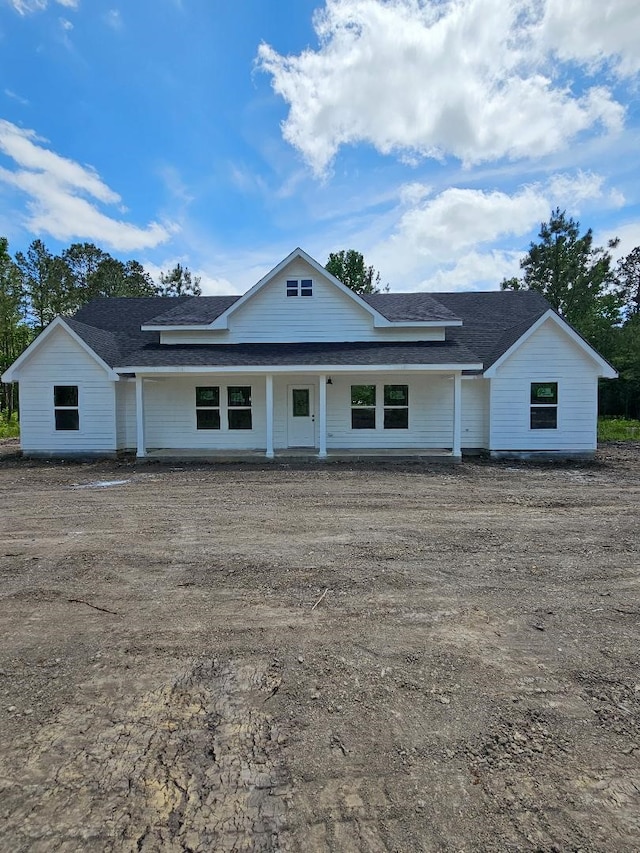 view of front of property featuring roof with shingles and a porch