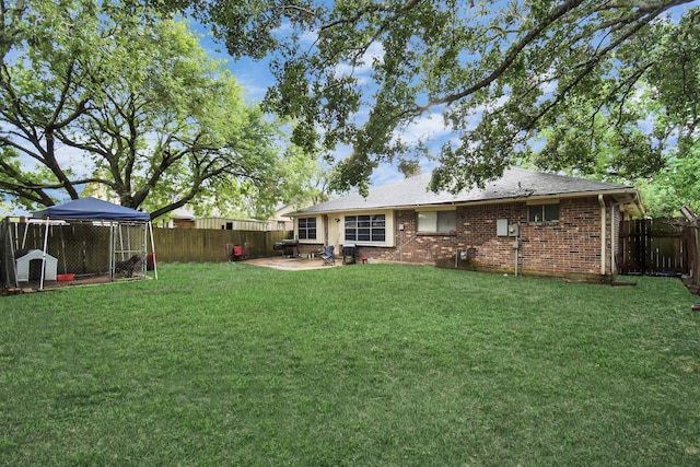 rear view of property with a patio, a yard, and a gazebo