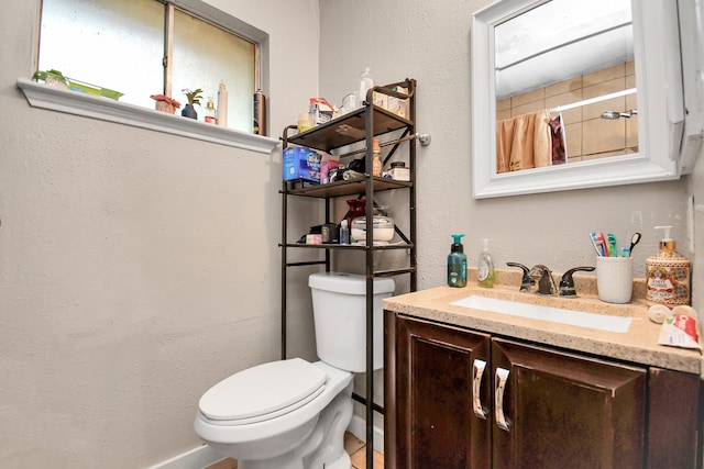 bathroom featuring walk in shower, vanity, tile patterned floors, and toilet