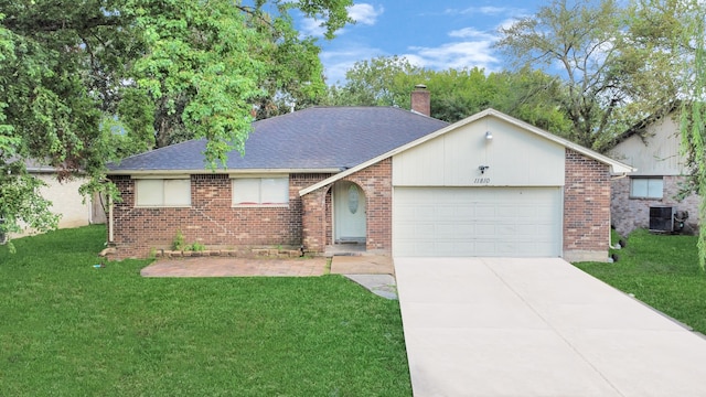 ranch-style house with central air condition unit, a garage, and a front yard