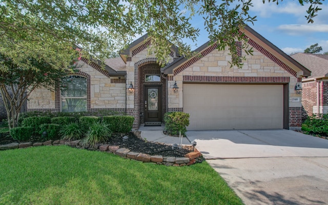 view of front of home with a garage and a front lawn