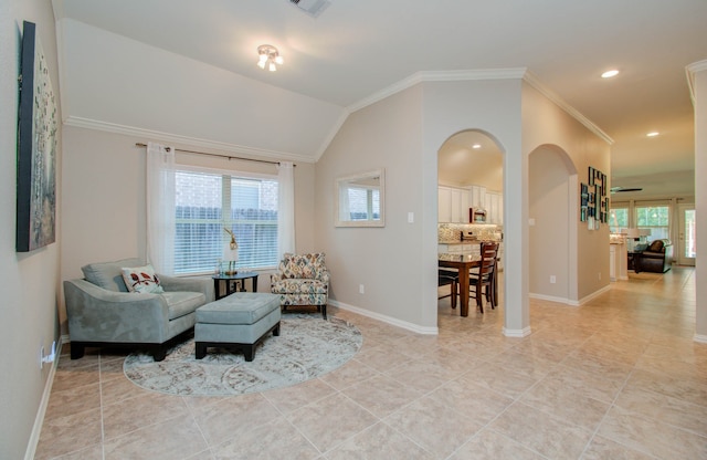 living area with lofted ceiling, crown molding, and plenty of natural light