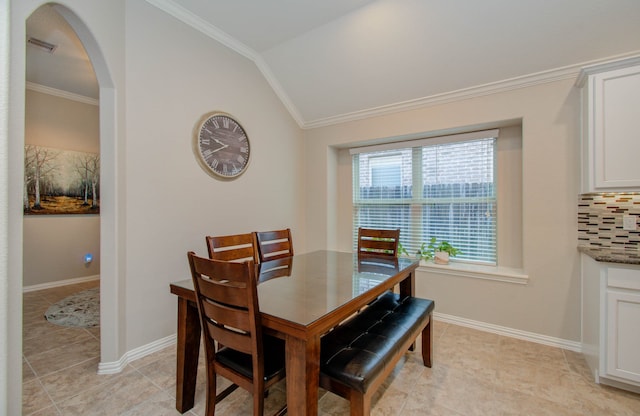 dining space with light tile patterned flooring, crown molding, and lofted ceiling