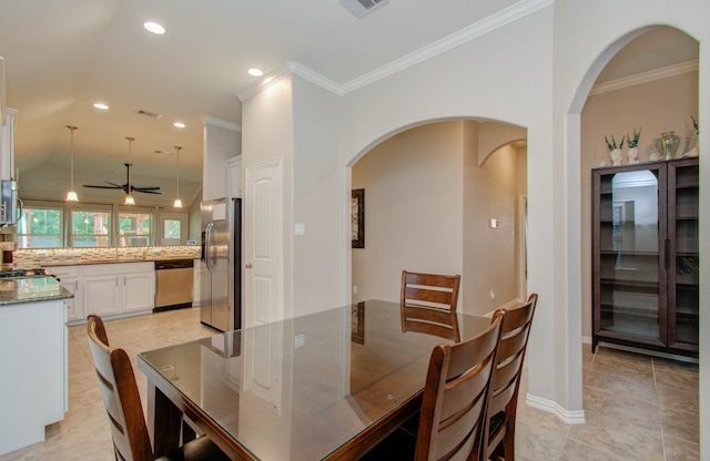 dining area with lofted ceiling, sink, light tile patterned flooring, ceiling fan, and crown molding