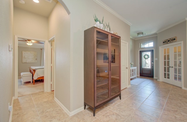 tiled foyer with french doors, ceiling fan, and crown molding