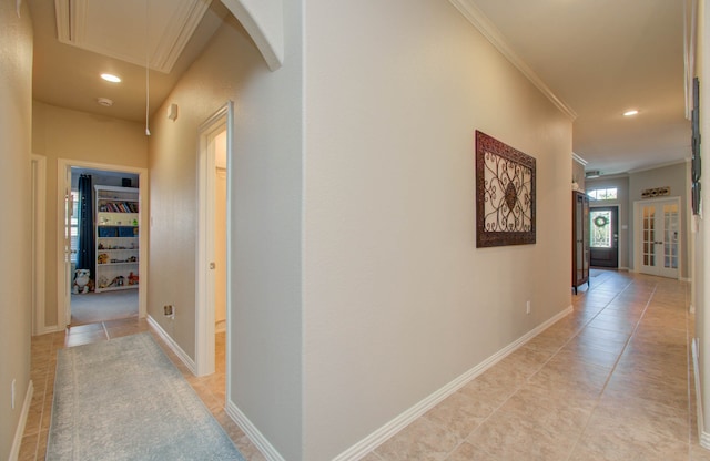 hall featuring light tile patterned floors and ornamental molding