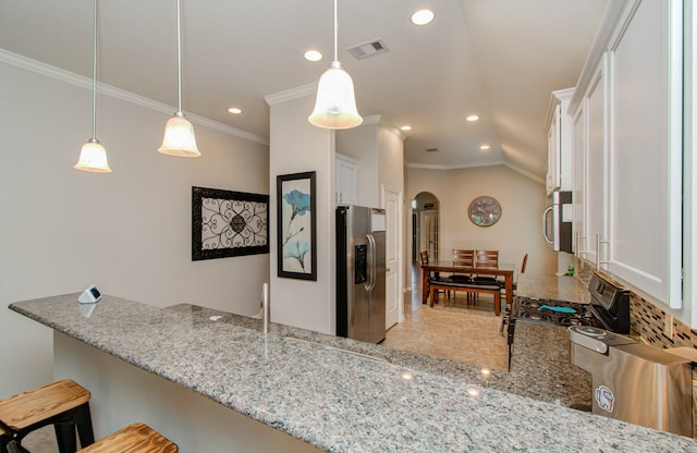 kitchen featuring pendant lighting, white cabinetry, appliances with stainless steel finishes, and light stone counters