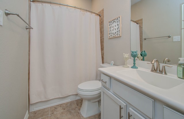 bathroom with toilet, vanity, and tile patterned floors