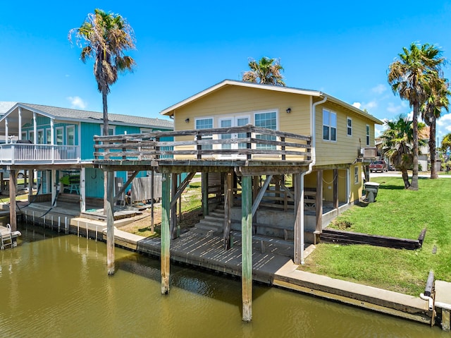 view of dock with a yard and a deck with water view