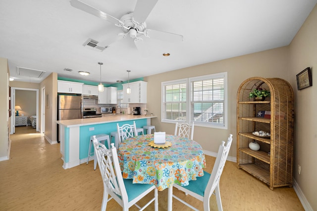 dining area featuring ceiling fan, sink, and light hardwood / wood-style flooring