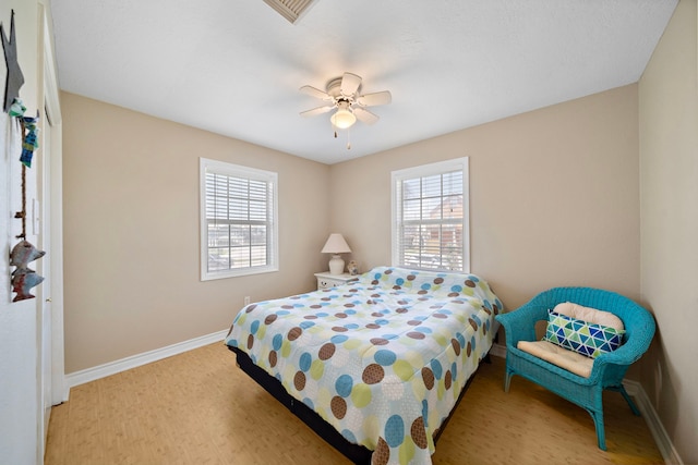 bedroom featuring light wood-type flooring, multiple windows, and ceiling fan