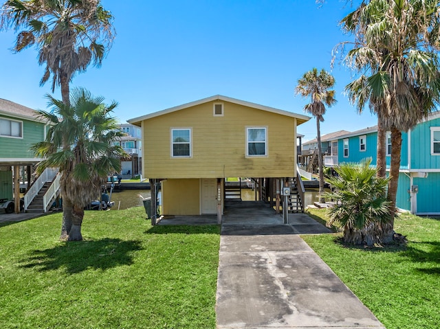 view of front of house with a carport and a front lawn