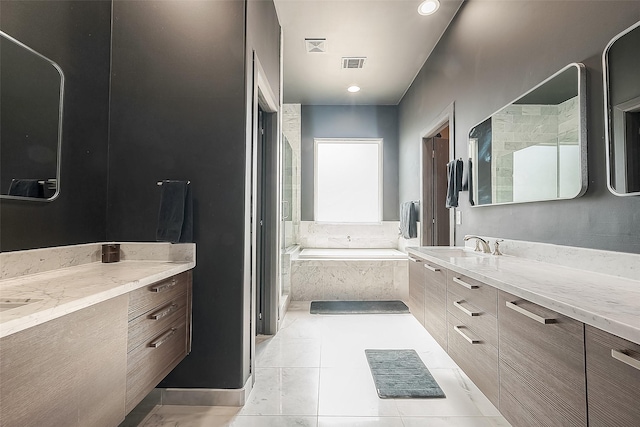 bathroom with a relaxing tiled tub, tile patterned floors, and vanity