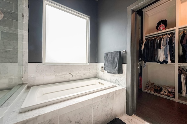 bathroom featuring tiled tub