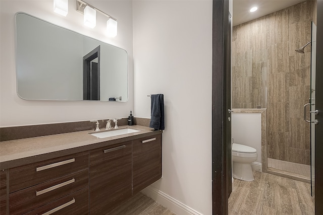 bathroom with vanity, hardwood / wood-style floors, toilet, and walk in shower