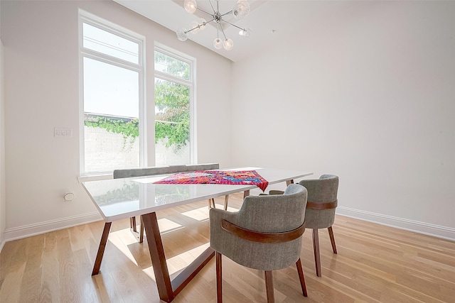 dining room with light hardwood / wood-style floors and a notable chandelier