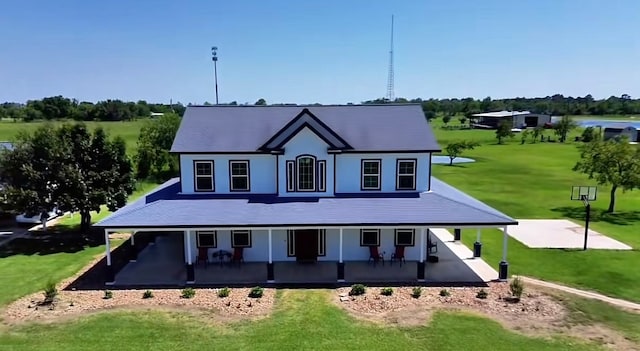 rear view of house featuring a yard and a porch