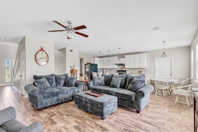 living room featuring light wood-type flooring and ceiling fan