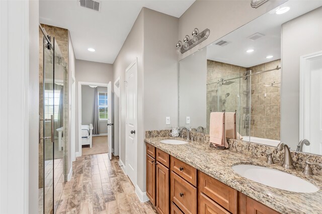 bathroom featuring vanity, an enclosed shower, and hardwood / wood-style flooring