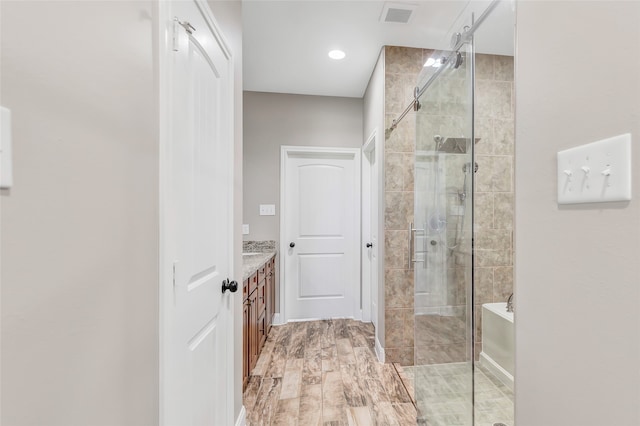 bathroom featuring wood-type flooring, vanity, and a shower with door