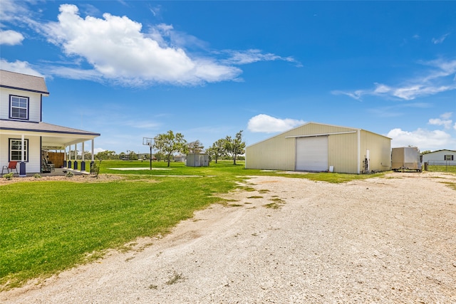 view of yard featuring an outbuilding, a garage, and covered porch