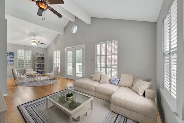 living room featuring ceiling fan, french doors, light hardwood / wood-style flooring, beamed ceiling, and high vaulted ceiling