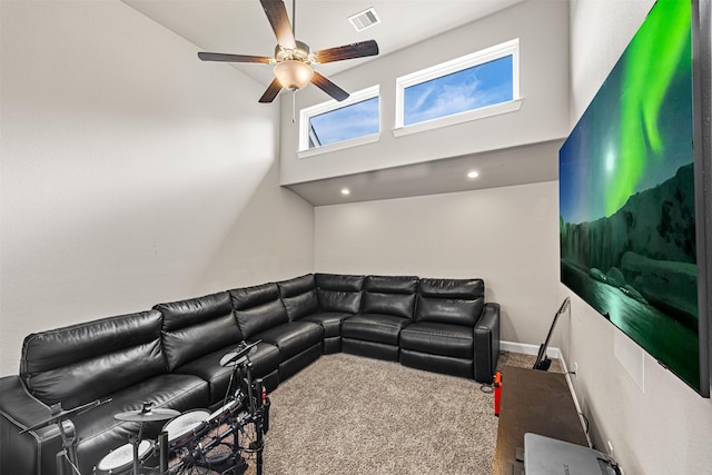 carpeted living area with ceiling fan, a towering ceiling, visible vents, and baseboards