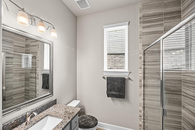 full bath with toilet, vanity, visible vents, baseboards, and a shower stall